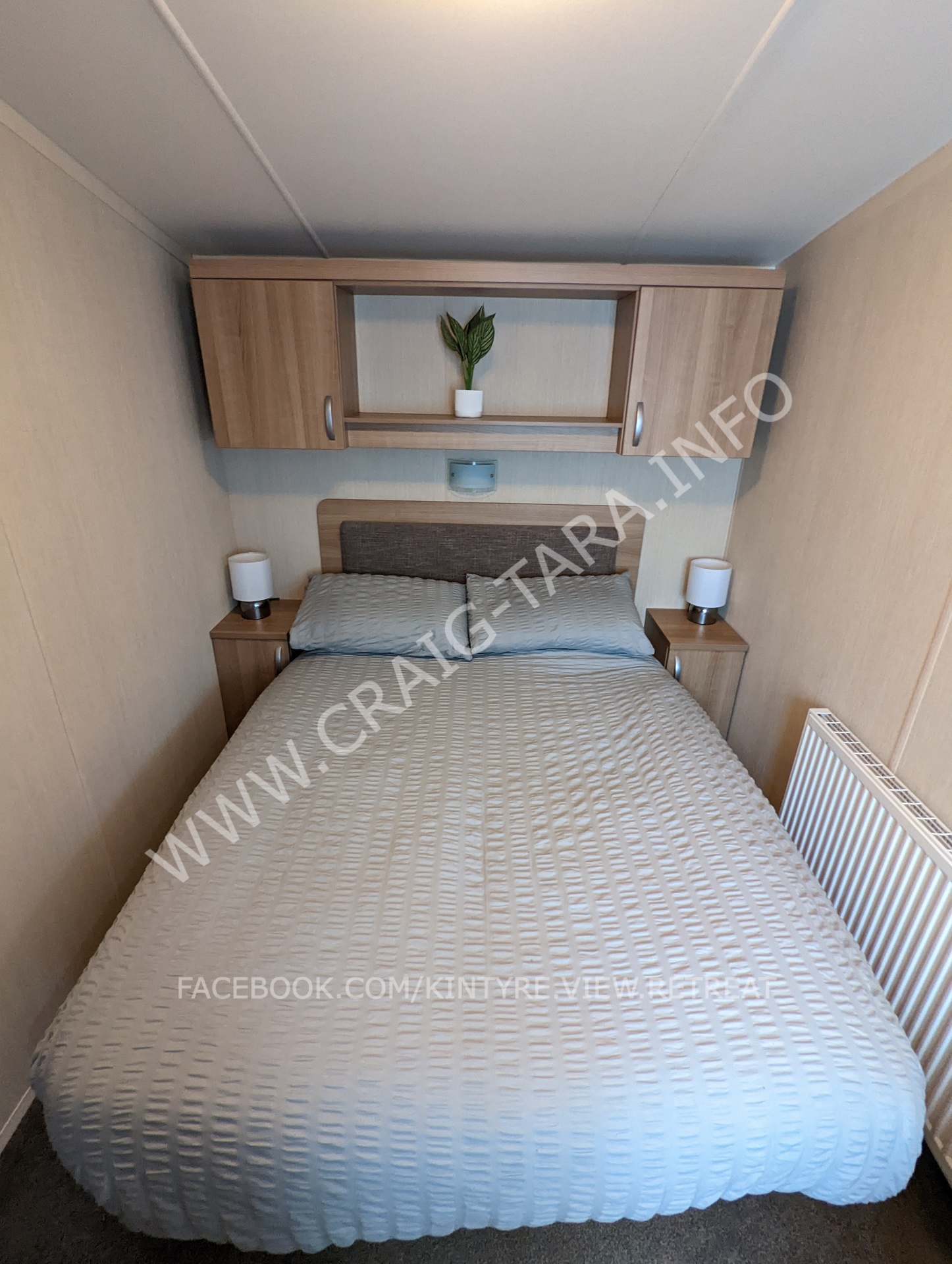 double bed in main bedroom with bedside lamps